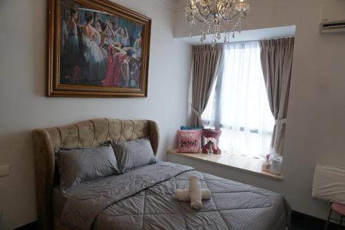 ein Schlafzimmer mit einem Bett, auf dem ein Stofftier liegt in der Unterkunft R&F Seine Region Victoria Style 3Bedroom in Johor Bahru