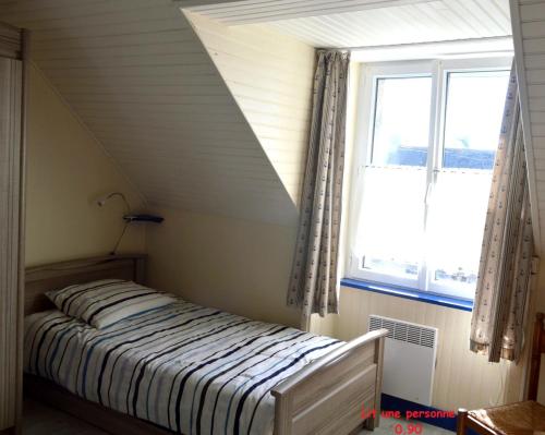 une chambre avec un lit et une fenêtre dans l'établissement PentyTy TadKozh Très proche du port de Kérity, à Penmarcʼh