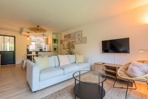 a living room with a couch and a tv at Maison 4 chambres avec jardin & garage proche tram in Wasquehal