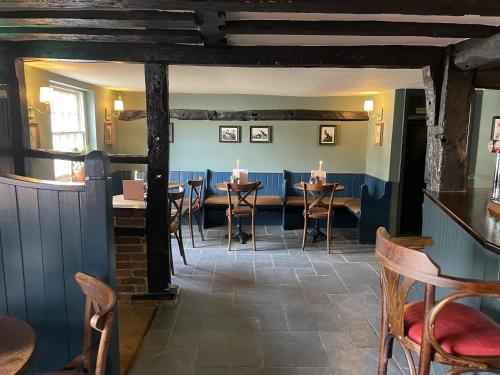 a restaurant with tables and chairs in a room at The Plume of Feathers in Farnham