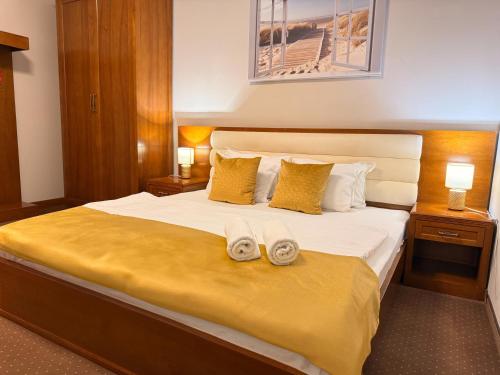 a bedroom with a large bed with two shoes on it at Vila Central in Constanţa