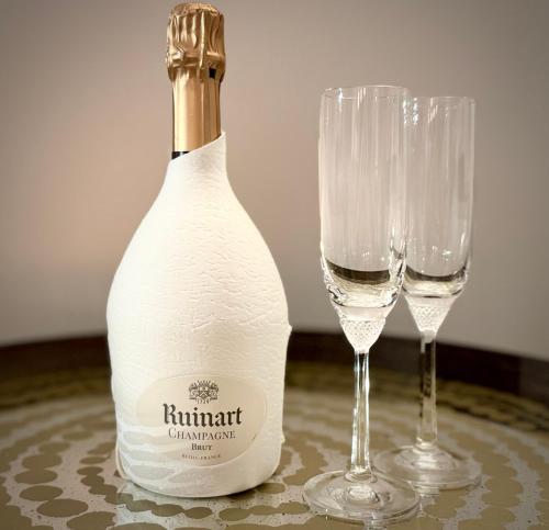 une bouteille de vin et deux verres sur une table dans l'établissement Superbe appartement avec Terrasse 1mn des plages de la Croisette, à Cannes