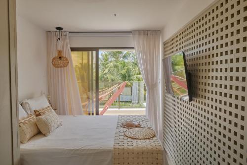 サン・ミゲル・ド・ゴストーゾにあるNovo Oásis em Gostoso Jacuzzi, Rooftop e Vista Incrívelのベッドと大きな窓のある寝室