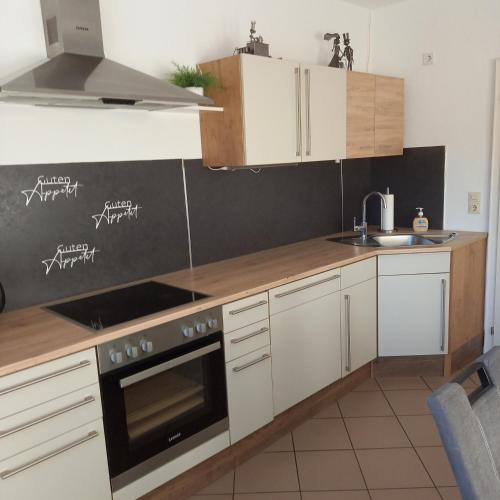 a kitchen with white cabinets and a stove top oven at Familienurlaub auf dem Erlenhof , Bauernhof 