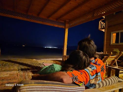 a man and a woman laying on a chair on the beach at Mountain Sinai camp in Wāsiţ