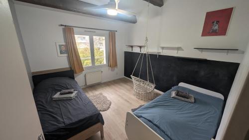 - une chambre avec 2 lits et une balançoire dans l'établissement Maison avec piscine privative aux beaux arts a montpellier, à Montpellier