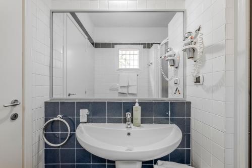 a bathroom with a white sink and a mirror at Allegroitalia Elba Golf in Portoferraio