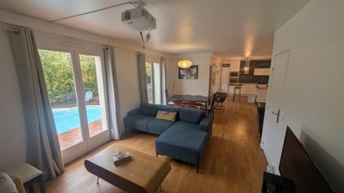 un salon avec un canapé bleu et une table dans l'établissement Maison avec piscine privative aux beaux arts a montpellier, à Montpellier