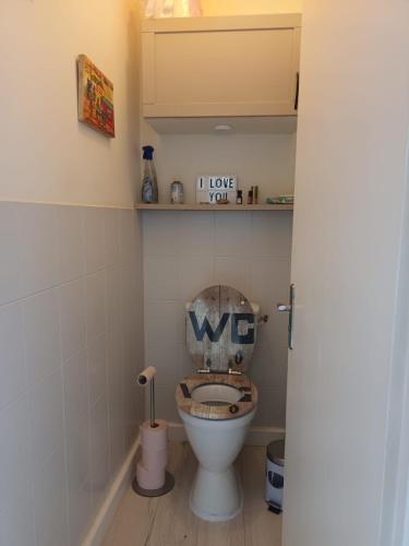 La salle de bains est pourvue de toilettes et d'un siège en bois. dans l'établissement Maison Port de la Côtinière à 150m de la plage, à Saint-Pierre-dʼOléron