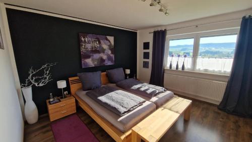 a bedroom with a bed and a large window at Urlaub am Sonnenhügl in Rinchnach