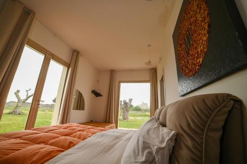a bedroom with a bed and a large window at Agriturismo Il Poeta Contadino in Merine