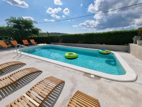 a swimming pool with three chairs and a swimming pool at Sweet room with a terrace in Roč