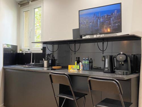 d'un bureau avec deux chaises et d'une télévision. dans l'établissement GuestReady - Sleek emerald escape in the 13th arr., à Paris