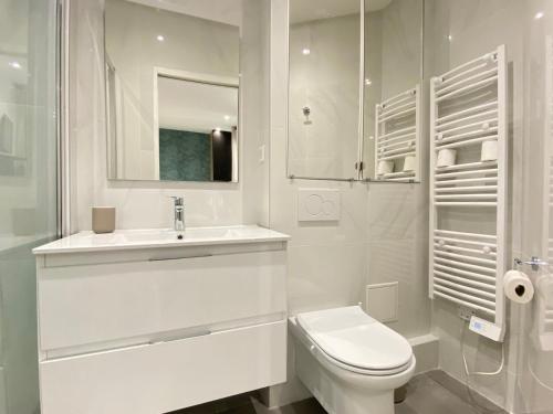 une salle de bain blanche avec des toilettes et un lavabo dans l'établissement GuestReady - Cozy green haven in Paris 13, à Paris