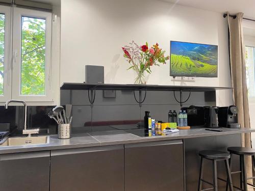 - une cuisine avec un comptoir orné d'un vase de fleurs dans l'établissement GuestReady - Warm and Stylish Nest in the 13th, à Paris