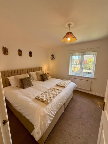 a bedroom with a large bed and a window at The Lakes in Stockingford