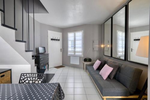 - un salon avec un canapé gris et des oreillers roses dans l'établissement 335 Mérindot 5 Au coeur du village, à Saint-Martin-de-Ré