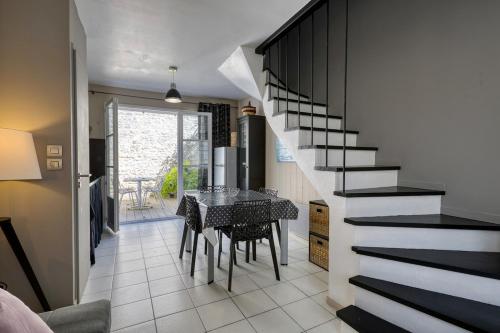 une salle à manger avec une table et un escalier dans l'établissement 335 Mérindot 5 Au coeur du village, à Saint-Martin-de-Ré