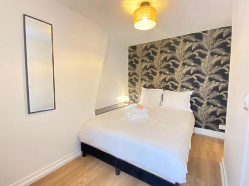 une chambre avec un grand lit avec un miroir dans l'établissement GuestReady - Cozy nest in Salpêtrière, à Paris