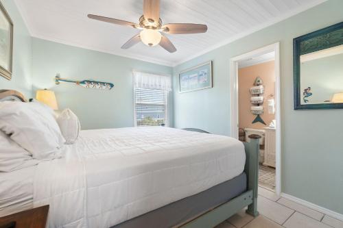 a bedroom with a white bed and a ceiling fan at Sea & Sun 204 by Vacation Homes Collection in Gulf Shores