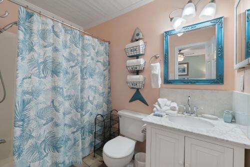 a bathroom with a toilet and a sink and a mirror at Sea & Sun 204 by Vacation Homes Collection in Gulf Shores