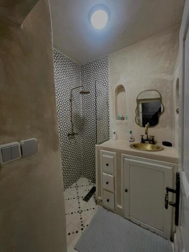 a bathroom with a shower and a sink and a mirror at Dar Lalla Rahma in Essaouira