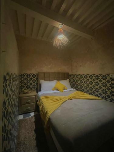 a bedroom with a bed with a yellow blanket at Dar Lalla Rahma in Essaouira