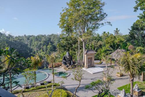 a garden with a statue and a pond at Hoshi Jungle Resort in Tegalalang