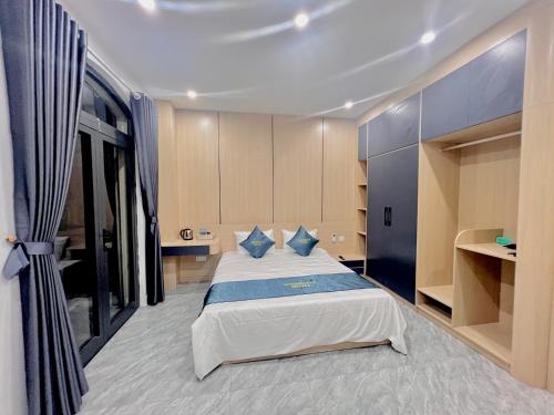 a bedroom with a large bed with blue pillows at Anna Belle Đồi Rồng Hotel - Homestay chuỗi HPT Home Hải Phòng in Kon Rung (1)