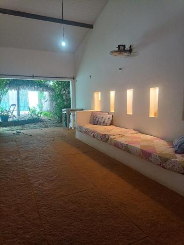 a bedroom with a large bed with lights on the wall at Vila Vento Virou in Cruz