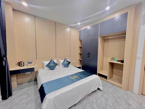 a bedroom with a large bed with blue pillows at Anna Belle Đồi Rồng Hotel - Homestay chuỗi HPT Home Hải Phòng in Kon Rung (1)