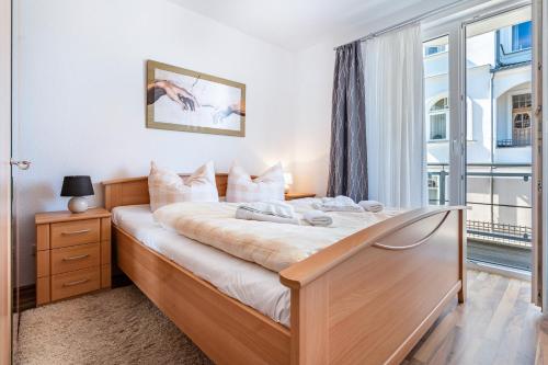 a bedroom with a large bed with a window at Fewo am Hochufer - erste Reihe in Ostseebad Sellin