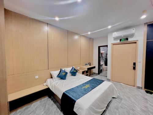 a bedroom with a large bed with blue pillows at Anna Belle Đồi Rồng Hotel - Homestay chuỗi HPT Home Hải Phòng in Kon Rung (1)
