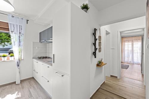 een keuken met witte kasten en een hal bij Apartments Frama Poreč - Funtana in Funtana