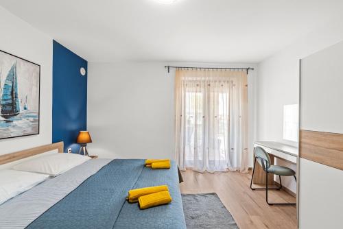een slaapkamer met een bed met gele kussens en een bureau bij Apartments Frama Poreč - Funtana in Funtana