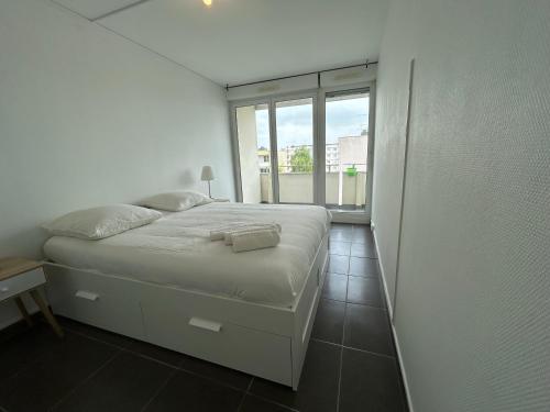 une chambre blanche avec un lit et une fenêtre dans l'établissement Mykonos, 4 Pers, Lumineux, Familial, Spacieux, à La Celle-sous-Gouzon