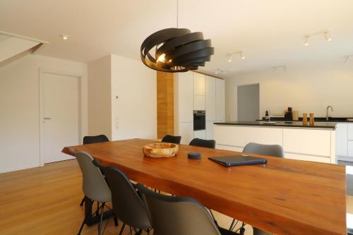 a kitchen and dining room with a wooden table and chairs at "Chalet H28" mit 4 Schlafzimmer in Todtnau-Muggenbrunn in Muggenbrunn