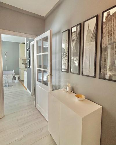 - un salon avec une table et des photos sur le mur dans l'établissement Le Petit Hermitage, à Le Touquet-Paris-Plage