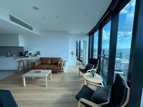 a living room with a couch and a table at Amazing City &River views 60th level skytower 3 bedrooms&Free parking in Brisbane