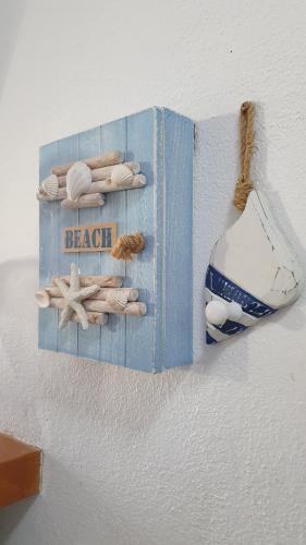 a blue book with shells and a beach sign at Stunning sea views apartment, pool, 5 min walk to beach, Winner of 2025 Travellers Choice award in Arenal d'en Castell