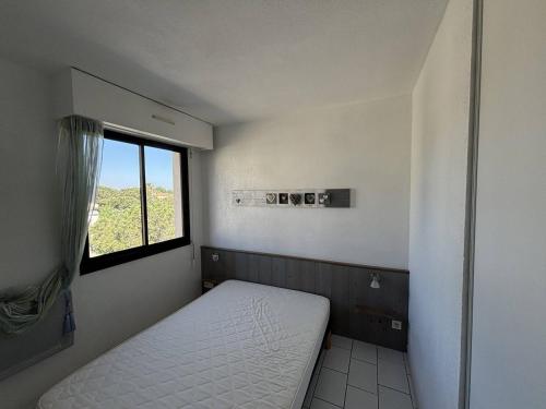 une petite pièce avec un lit et une fenêtre dans l'établissement 2 Pièces Cabine avec Terrasse et Parking, 150m Plage - Argelès-sur-Mer - FR-1-388-79, à Argelès-sur-Mer