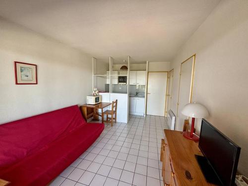 un salon avec un canapé rouge et une cuisine dans l'établissement Appartement 2 pièces + cabine, 6 couchages, proche plage, parking - FR-1-388-44, à Argelès-sur-Mer