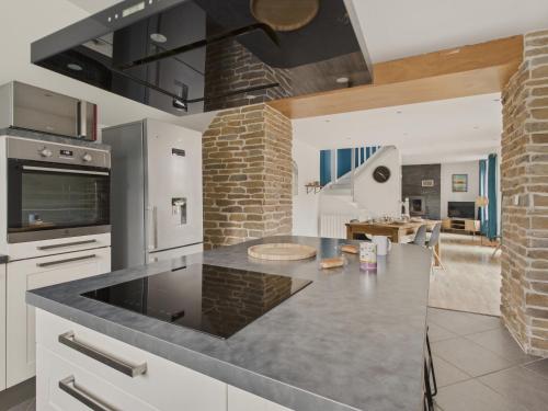 - une cuisine avec un comptoir et une cuisinière four supérieur dans l'établissement Jolie maison avec jardin et terrasse pour 4, à Fouesnant
