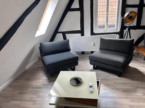 a living room with two chairs and a coffee table at Loftcharakter unter historischem Gebälk in Nidderau