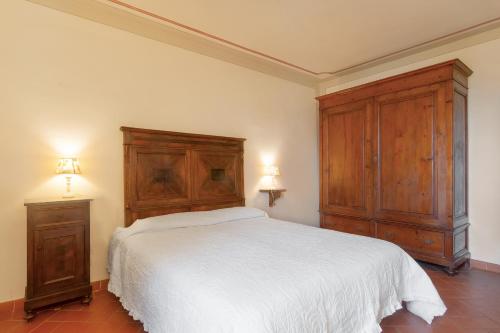 a bedroom with a white bed and wooden cabinets at Universal Harmony - Nibbio in Dicomano