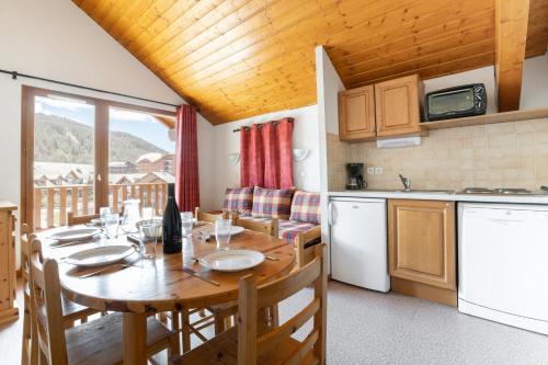 Il comprend une cuisine et une salle à manger avec une table en bois. dans l'établissement Appartement vue sur les pistes, pour 8, à La Joue du Loup