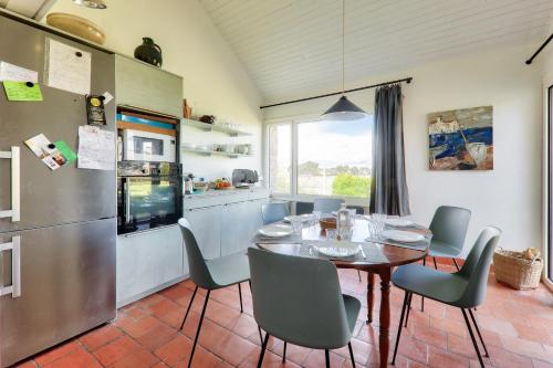 une cuisine et une salle à manger avec une table et des chaises dans l'établissement Vue mer et acces plage direct pour 11 personnes, à Saint-Gildas-de-Rhuys