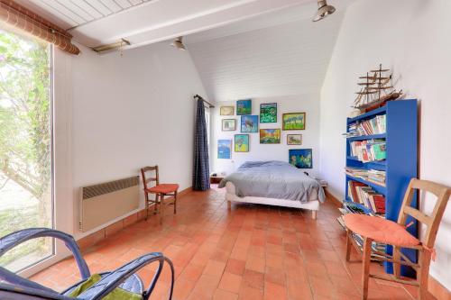 a bedroom with a bed and a book shelf at Vue mer et acces plage direct pour 11 personnes in Saint-Gildas-de-Rhuys