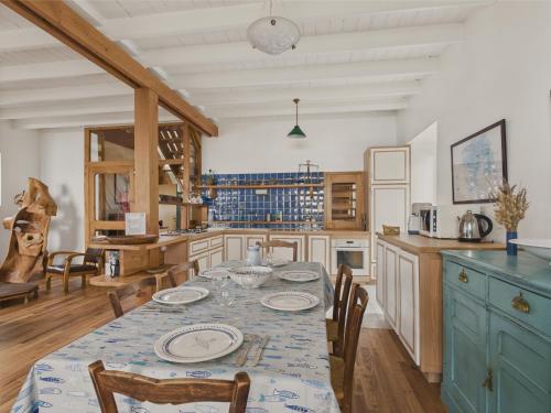 une cuisine avec une table avec des assiettes dessus dans l'établissement Grande maison vue mer et acces plage direct pour 7, à Bénodet