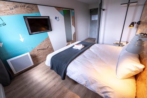 a bedroom with a bed and a tv on the wall at The Originals Access, Hôtel Clermont-Ferrand Nord in Châteaugay